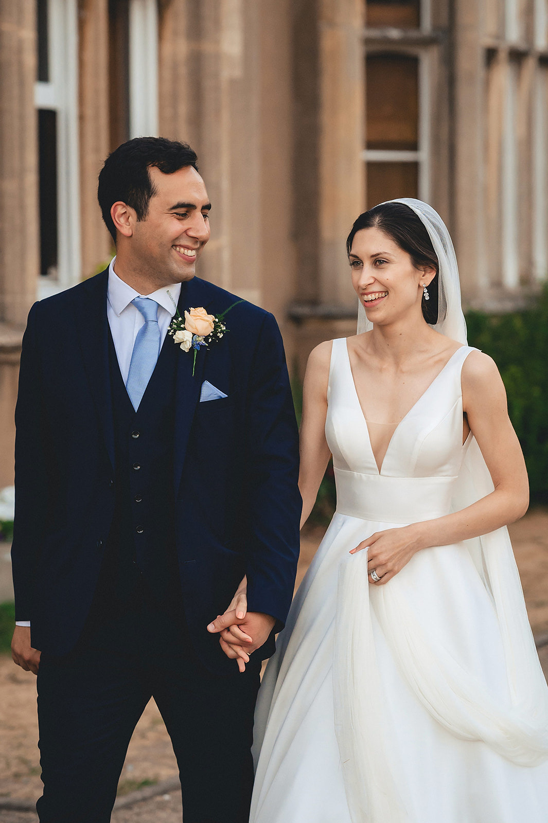 Emma and Raif smiling at each other outside Nonsuch Mansion