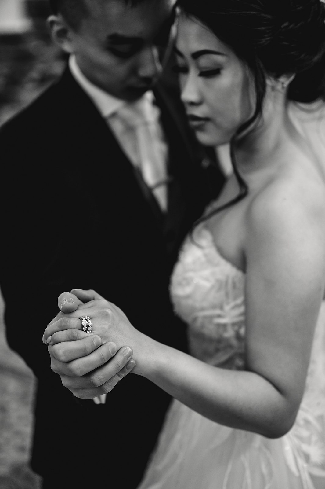 A couple holding hands in a black and white portrait