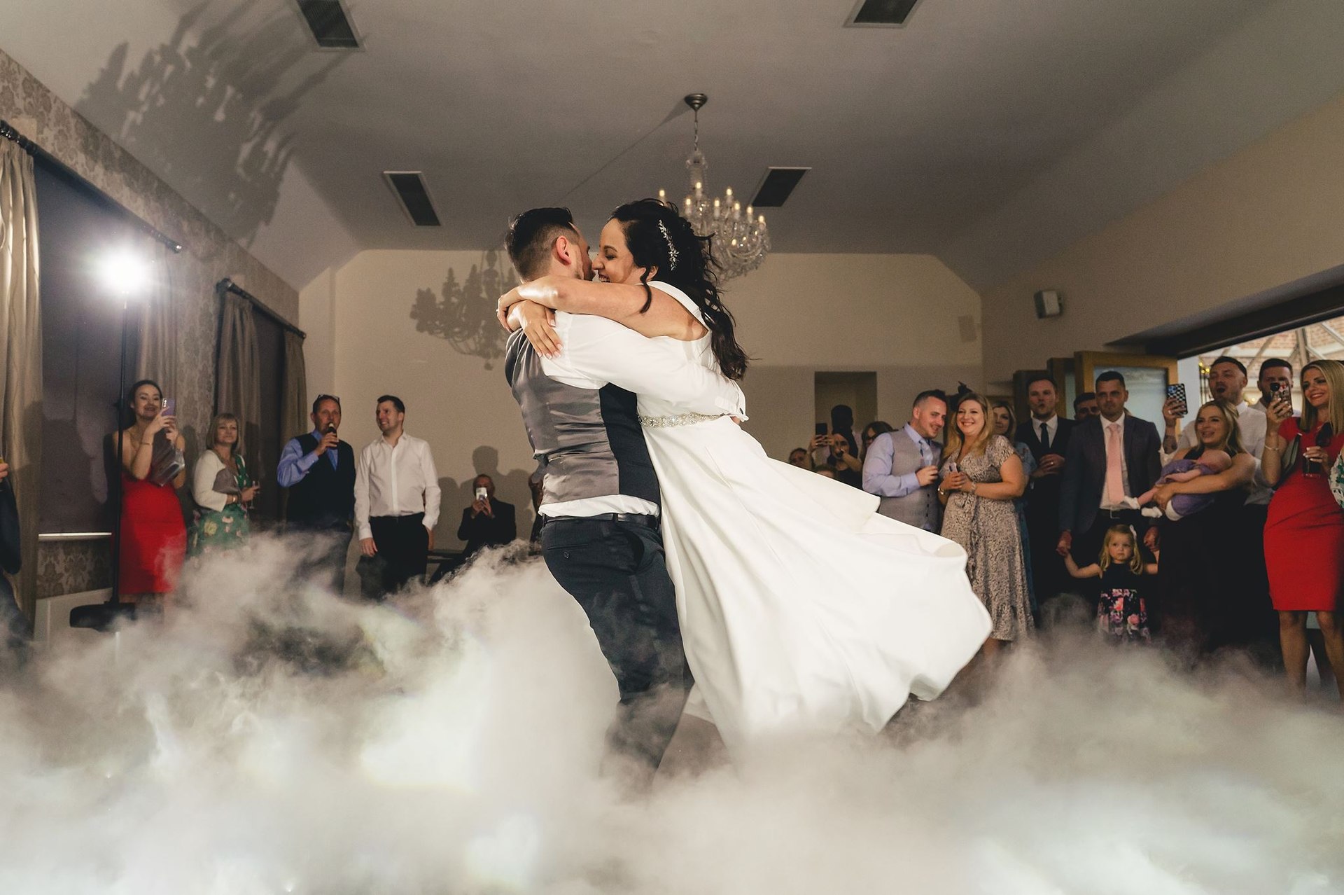 A couple sharing their first dance amid low clouds