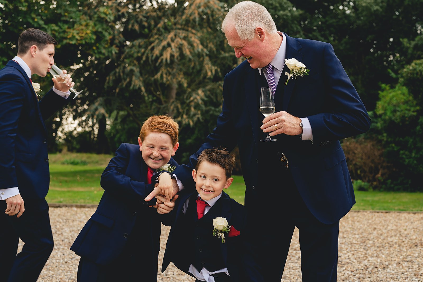 A groom laughing with children at a wedding