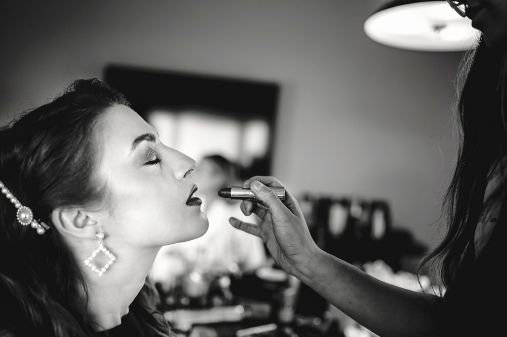 Bride getting ready with lipstick from makeup artist